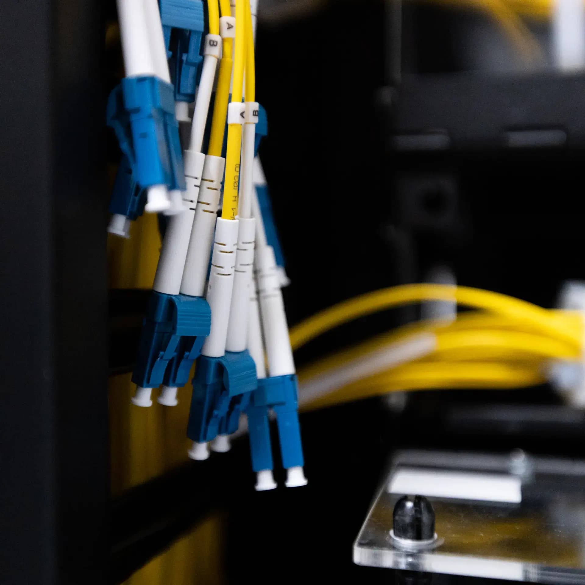 Bundle of LC duplex single-mode fiber jumpers on yellow OS2 cable